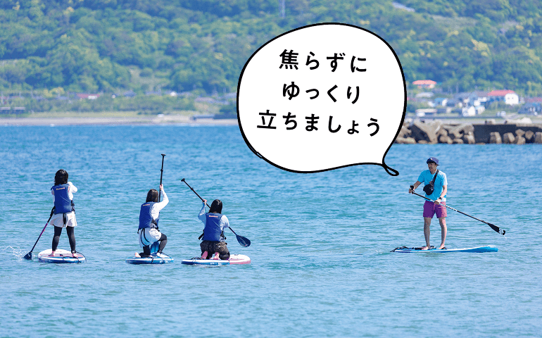 海上でボードに立つスタッフと参加者たち
