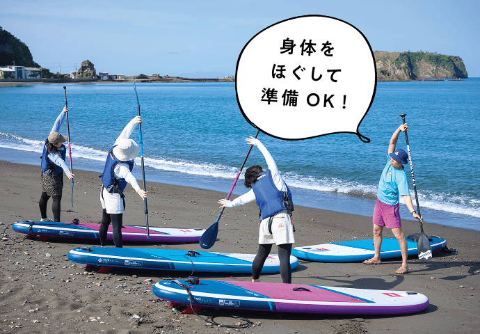 浜辺でストレッチをする参加者
