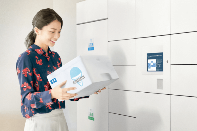 冷凍冷蔵ボックスから荷物を取り出す住民