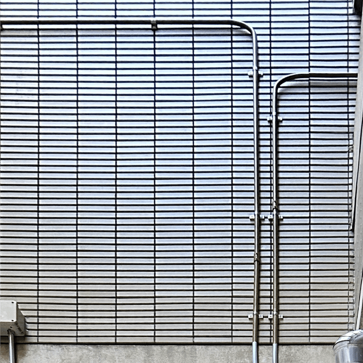 地下のMDFから1階まで伸びるステンレス製の露出配管