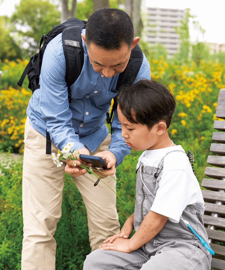 スマホのアプリで生きものの名前を調べる2人