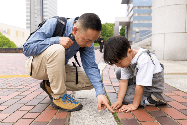 道端にしゃがんで観察する2人
