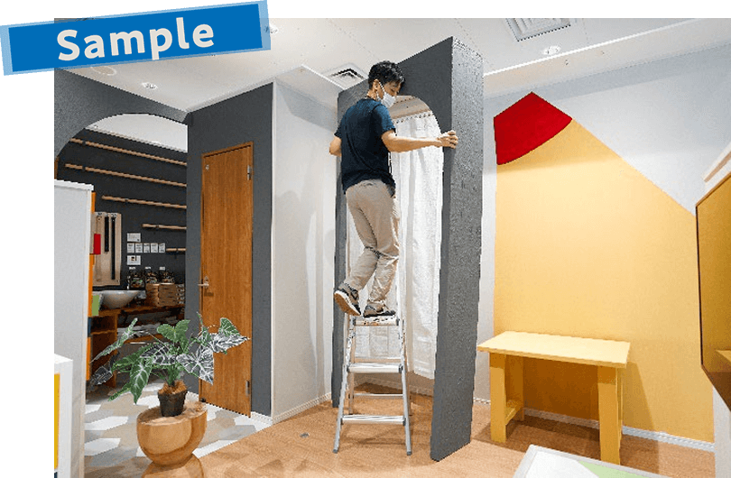 間仕切りとして使う大きなアーチを設置する男性