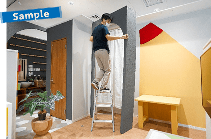 間仕切りとして使う大きなアーチを設置する男性