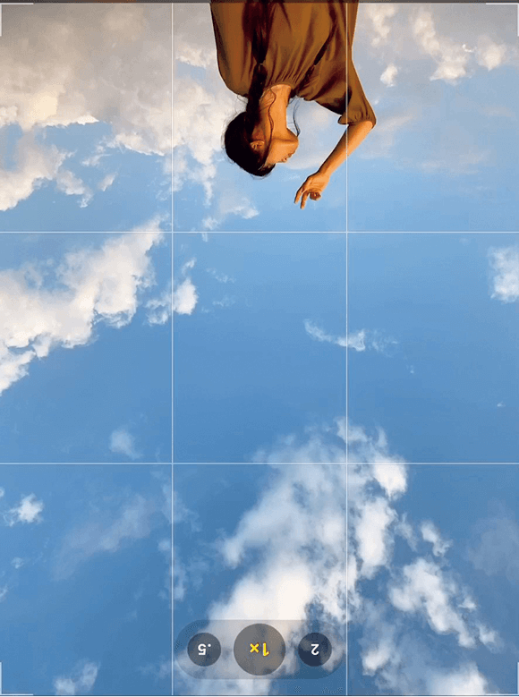 空と地面が逆になった撮影画面で上部に女性が映っている