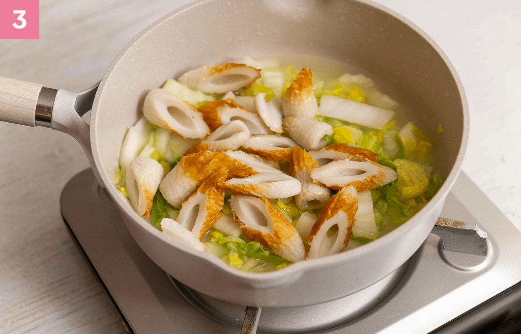 切ったちくわと水を加えて煮る様子