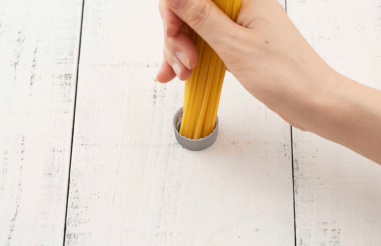 ペットボトルのキャップでパスタの束を計る様子