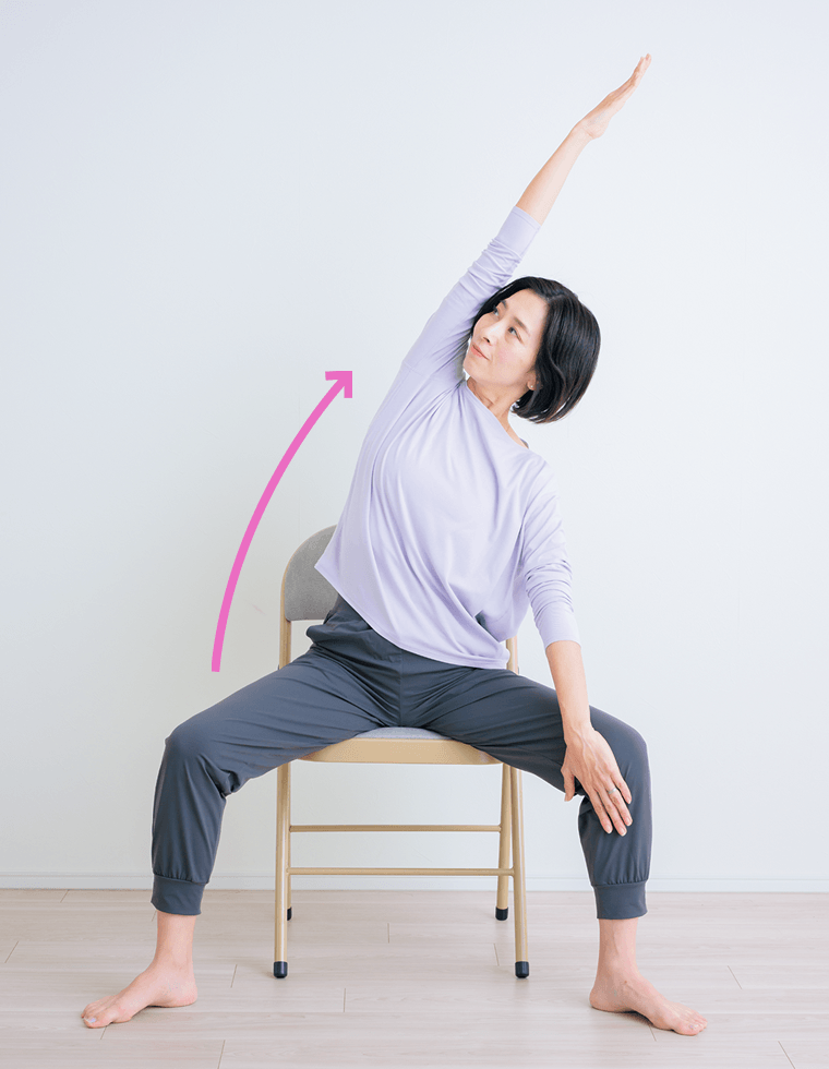 椅子に座って腕を上げる先生