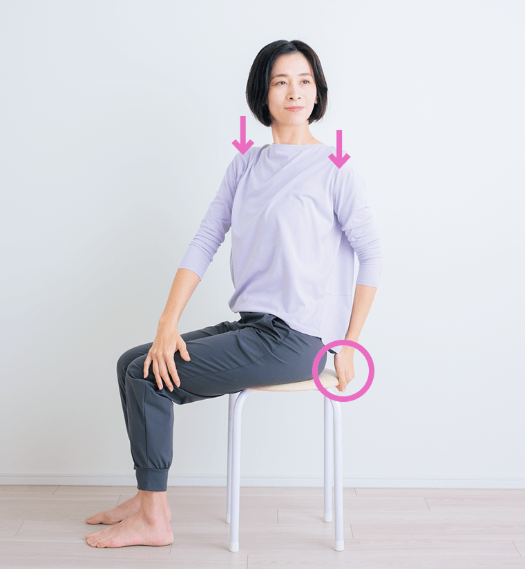 椅子の上で胸を持ち上げ反らし息を吸い込む先生