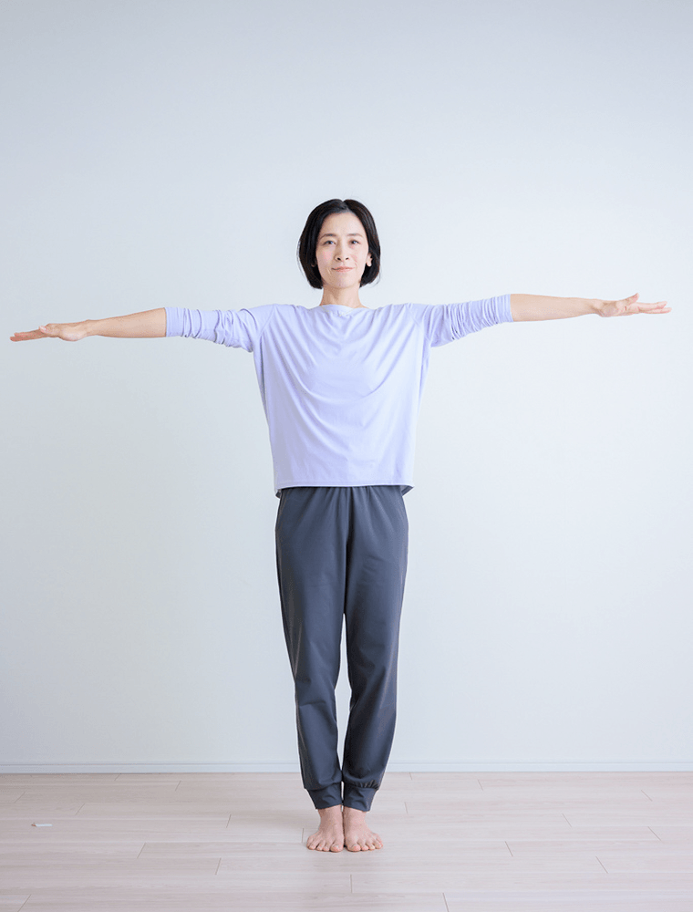 腕を大きく左右に広げる先生