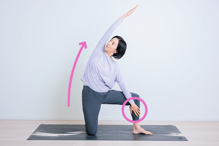 片膝を広げて伸びる先生