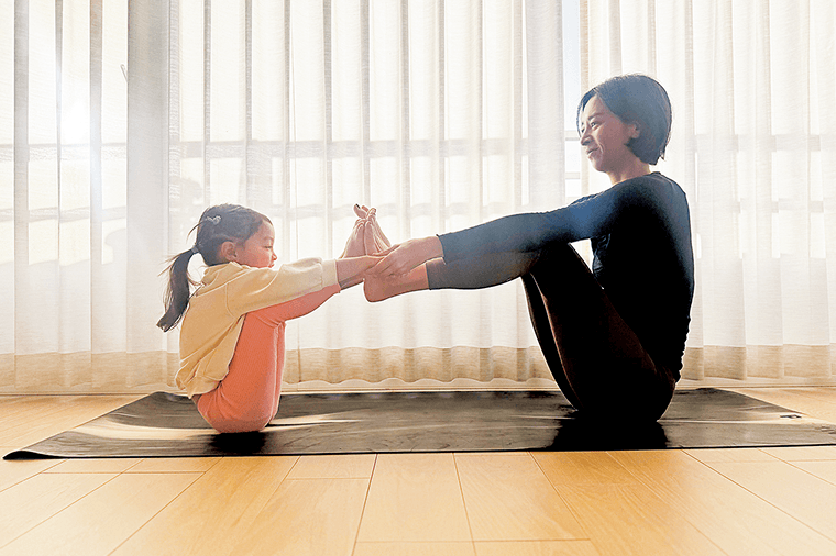 足の裏を合わせて押し合いながらゆっくり持ち上げる親子