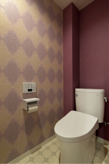 トイレの写真：紫を基調とした壁紙。1面はアーガイル柄のクロス。